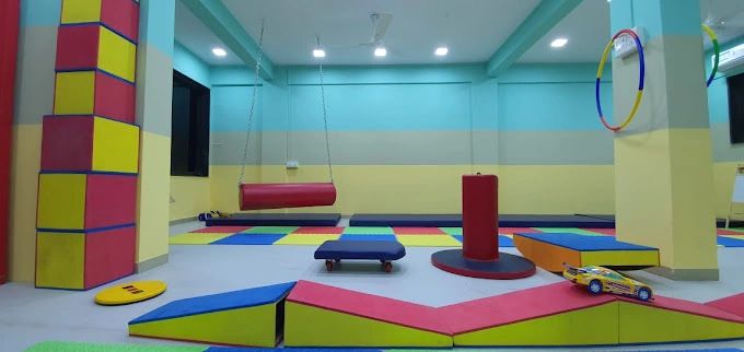 Sensory integration and occupational therapy room at CRC Chembur with therapy swings, colorful floor mats and balance equipment.