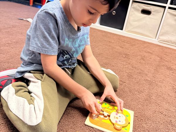 Child challenging himself with puzzles in Rising Star Child Care Houston Texas center 77090.