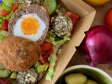 middle eastern scotch egg seved with a soft mint herb cheese and salad at baba's mezze