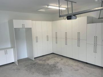 Clean garage with white storage cabinets.