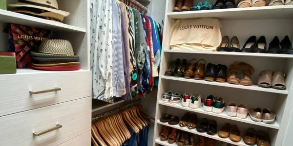 Organized closet with shoes, clothes, hats, and Louis Vuitton bags.