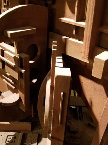 An abstract wooden sculpture with geometric shapes and intricate details.