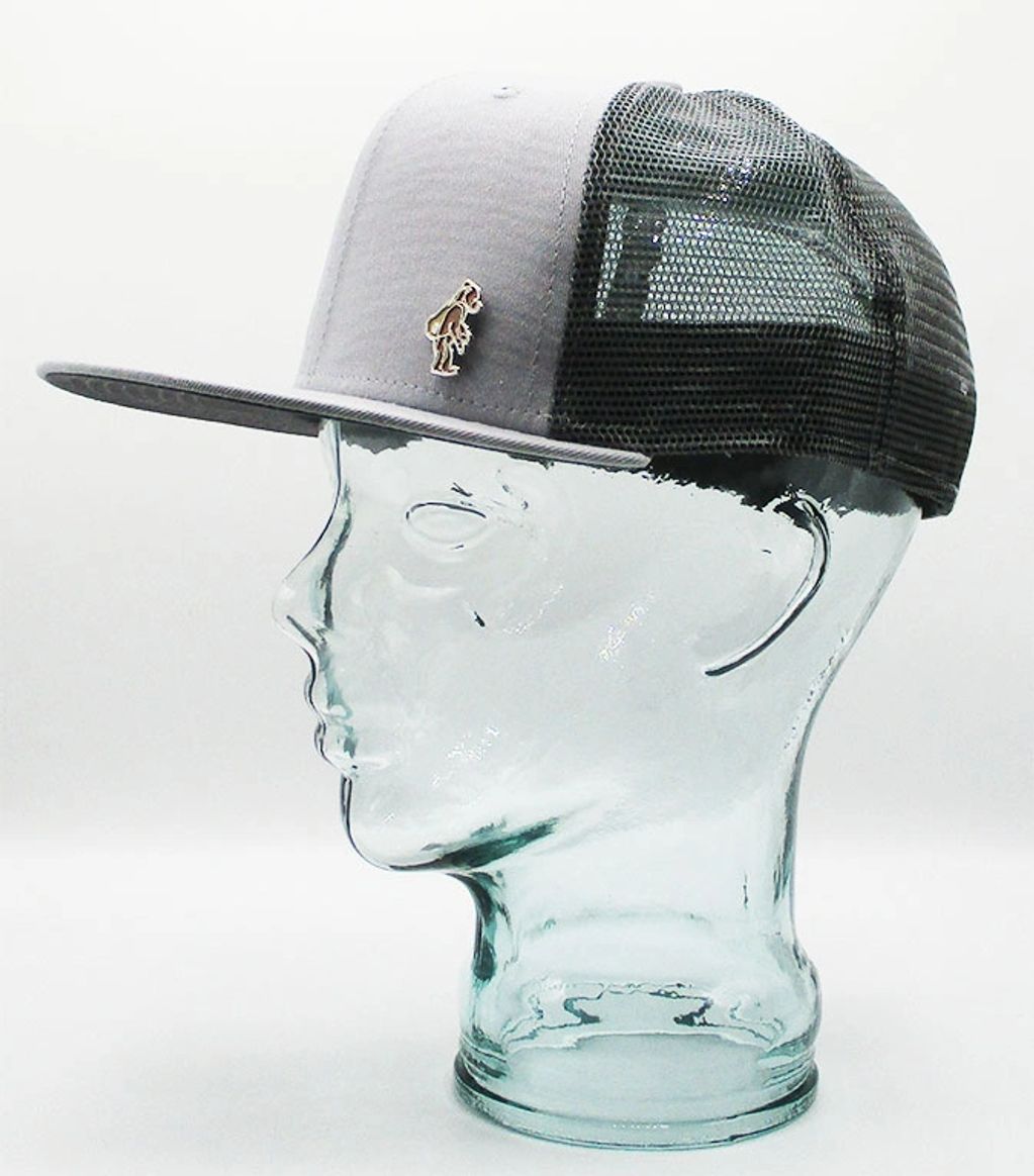 Gray and black mesh trucker hat displayed on a glass mannequin head.