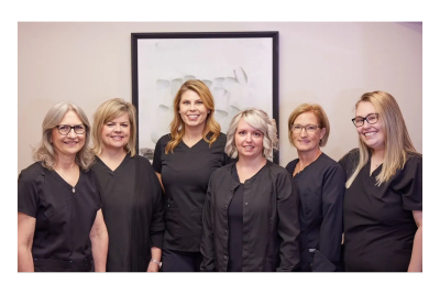 Group photo of six women in black uniforms smiling.
