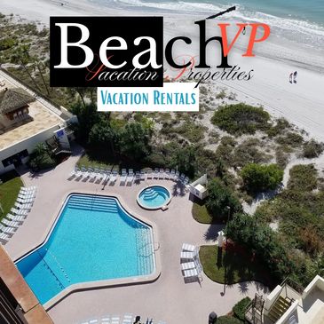 Aerial view of a beachfront pool and lounge area with the ocean in the background.