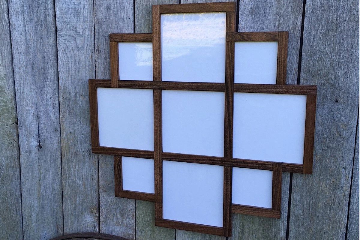 9 opening frame for 2 different sizes of square pictures stained Mahogany hanging on a barn.