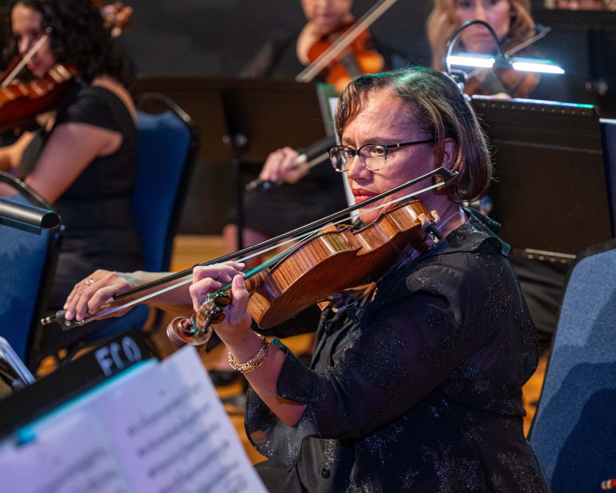 Stack of books next to pencils in a holder and a camera.