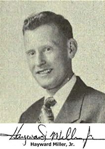 Black and white portrait of a smiling man in a suit and tie.