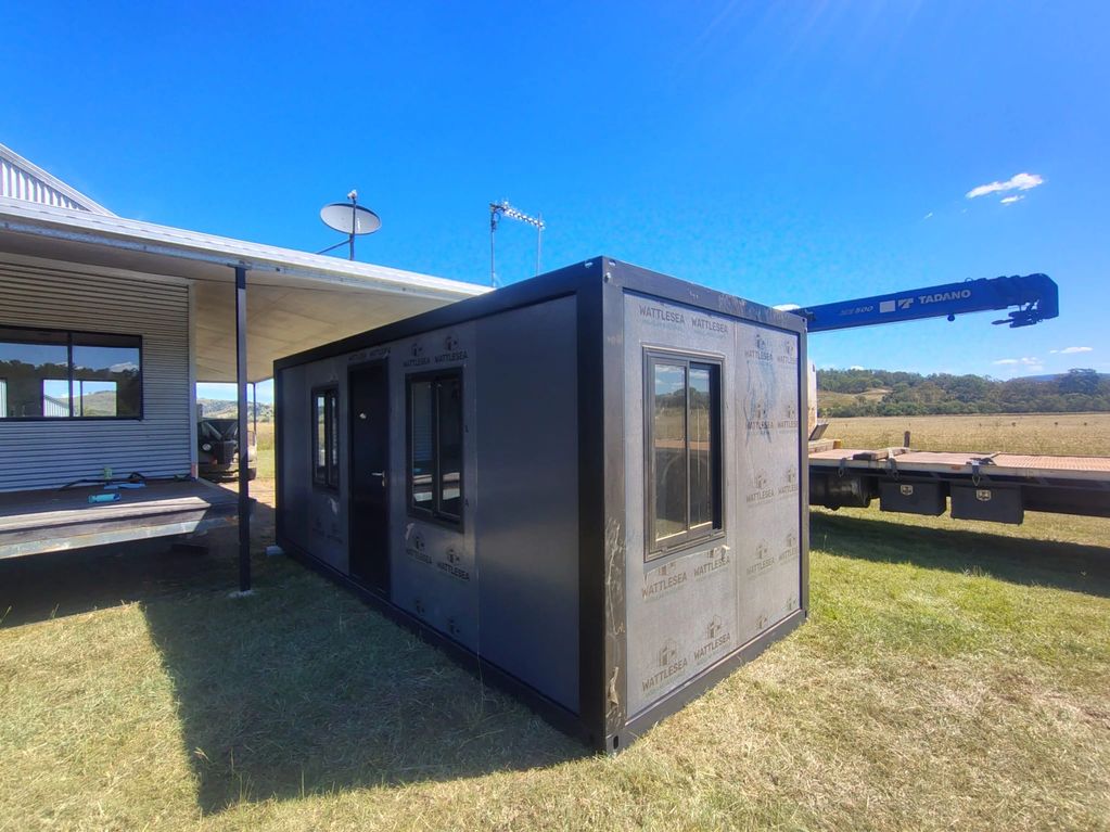 A small modular building unit outside under a clear blue sky.