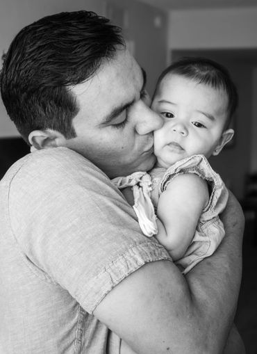 father kissing young baby