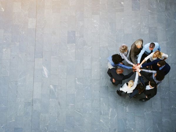 High angle view of a team of businessmen standing together with their hands together