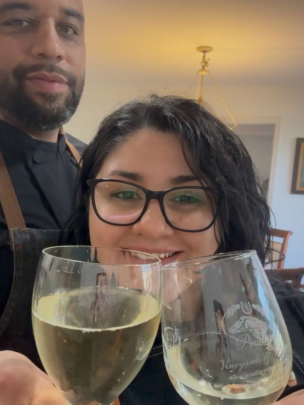 Couple toasting with wine glasses indoors.