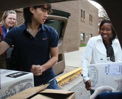 High school students loading boxes of food they collected into a pickup car.