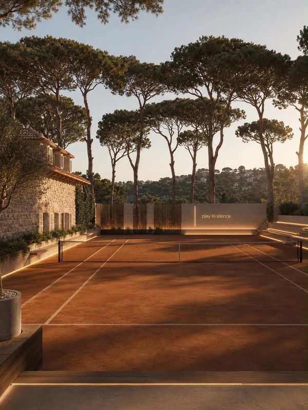Serene tennis court at sunset with a 'play in silence' sign.