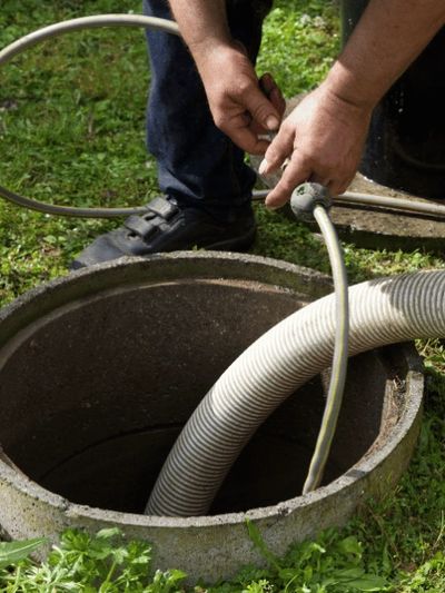 Septic technician inspecting an open septic tank during septic pumping service in Mount Laurel, NJ t