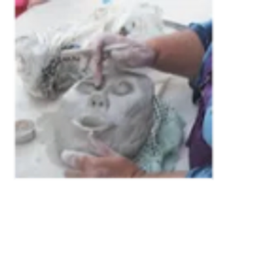 Kathie's hands in action as she sculpts one of her clay faces