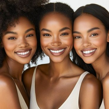 Three smiling women with diverse hairstyles and glowing skin.