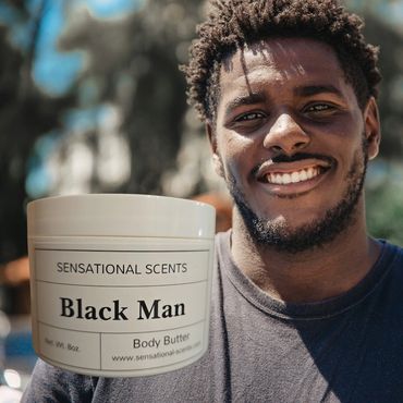 Smiling man holding a container of Black Man body butter by Sensational Scents.