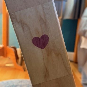 Red heart painted on wooden surface.
