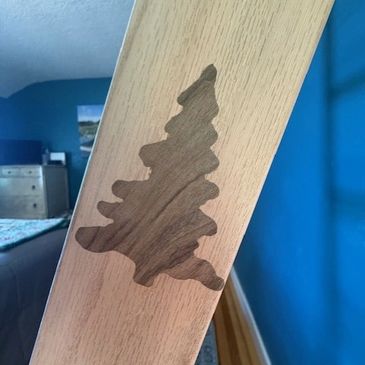 Wood inlay of a tree on a wooden surface.