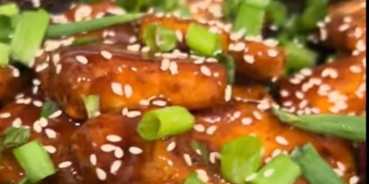 Sticky glazed tofu with sesame seeds and green onions.