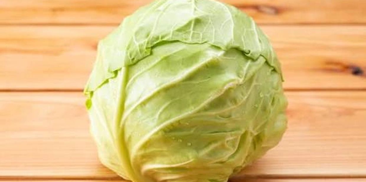 Fresh green cabbage on a wooden surface.