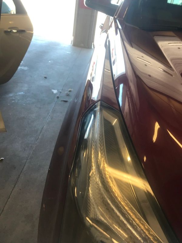 The after photo of a big crease dent on right fender