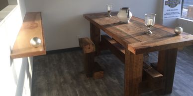 Wood work table in an office with a white vase and silver and glass candle holders, wood shelf 