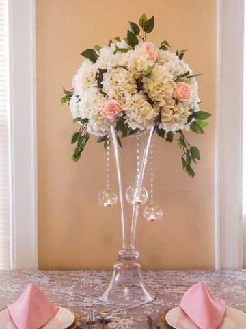 elegant tall wedding flower centerpieces with hanging candles and diamonds. clear trumpet vase