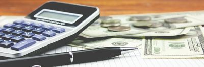 A calculator and pen with cash