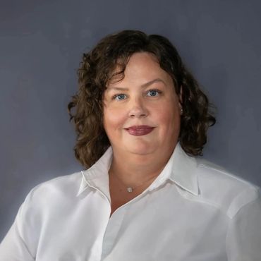 Professional headshot of Austin woman in white blouse on clean gray studio background