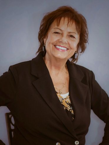Headshot of Austin professional woman in black blazer on soft gray background