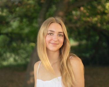 Senior girl smiling in natural outdoor setting during portrait session in Austin