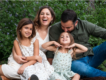 Family of four laughing together outdoors in an Austin park a relaxed family photography session