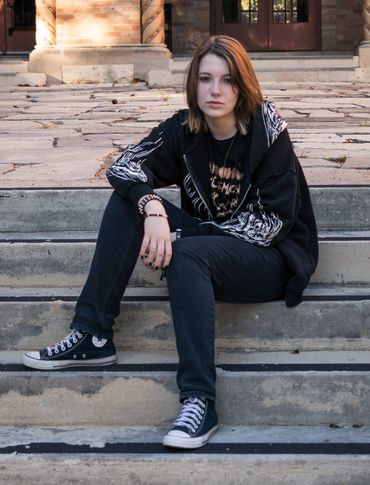 Austin senior portrait of a girl sitting on stone steps during an outdoor senior photo session.