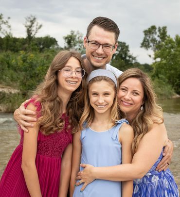 Austin family of four smiling during an outdoor portrait session.