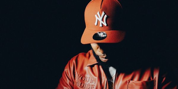 C. Titus with his head down under a red Yankees cap, in a red leather jacket