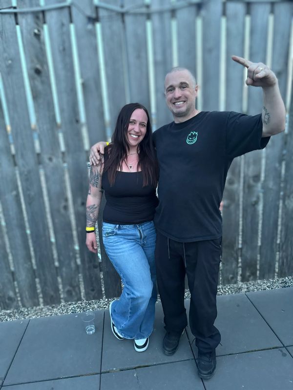 Smiling couple posing in casual clothes outdoors.