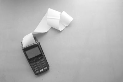 Payment terminal with a long receipt roll on an orange background.