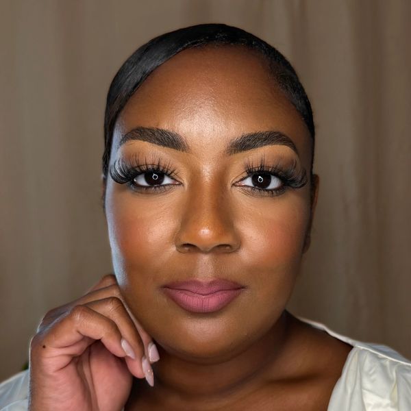 Close-up of a woman with bold makeup and long eyelashes.