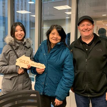 happy vietnamese buyers at real estate settlement table