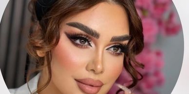 Close-up of a woman with glamorous makeup and styled hair.