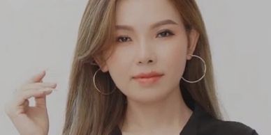 Portrait of a woman with hoop earrings and light makeup.