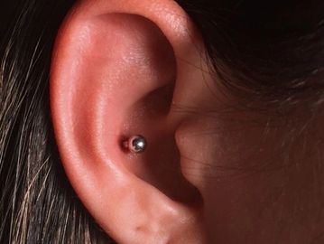 Close-up of an ear with a daith piercing.