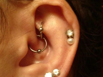 Close-up of an ear with multiple piercings and earrings.