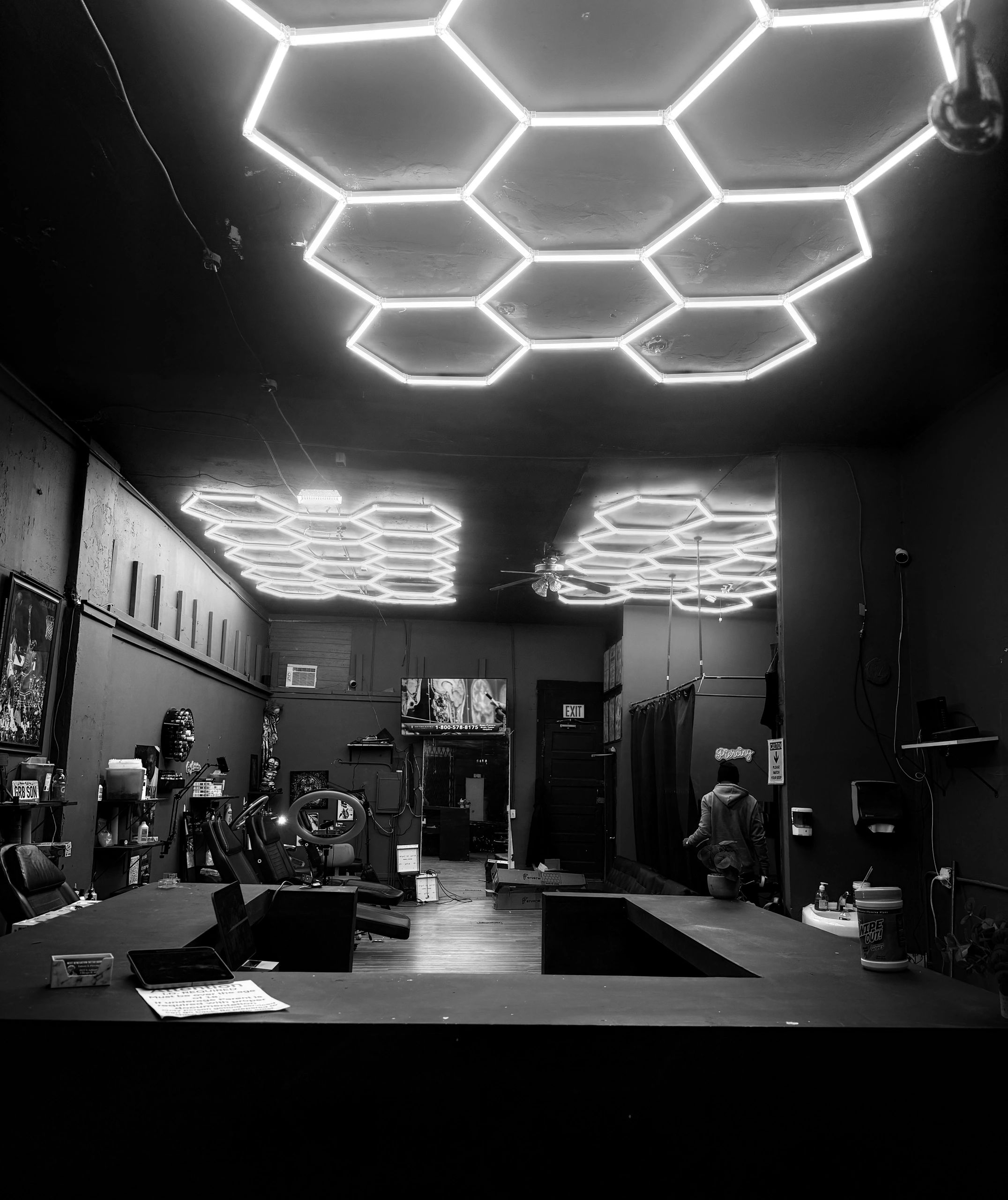 Interior of a room with hexagonal ceiling lights and a person walking.