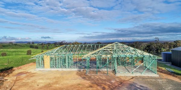 House framing under construction in a rural area.