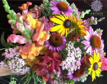 Vibrant mixed flower bouquet with yellows, purples, pinks, and oranges.