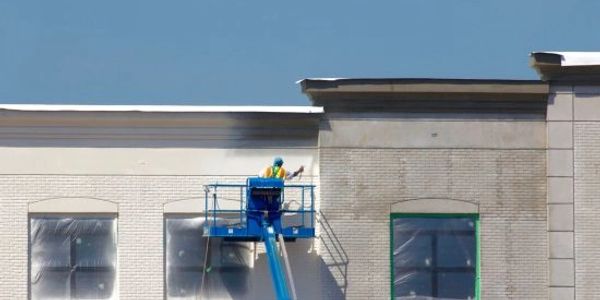Man painting commercial buildings