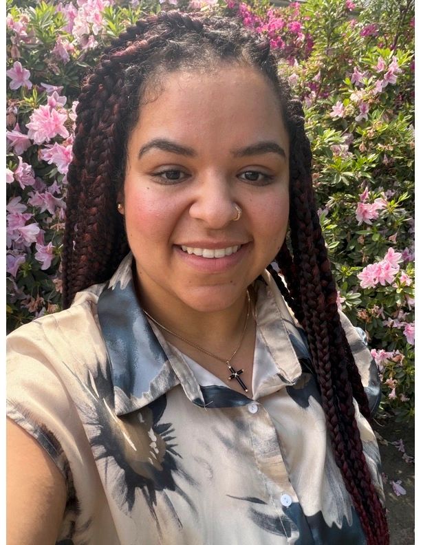Stack of books next to pencils in a holder and a camera.